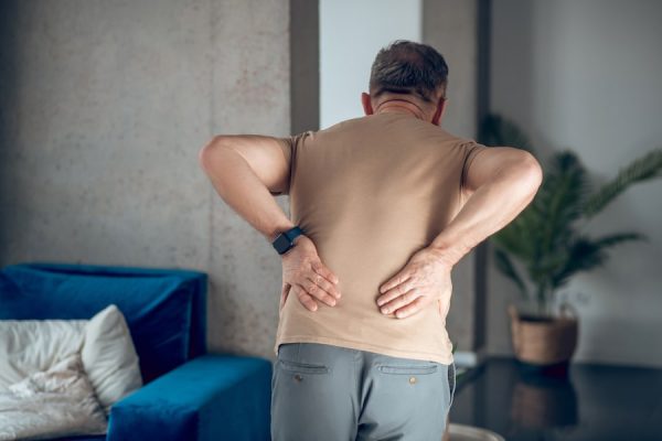 A man hunched over with back-pain